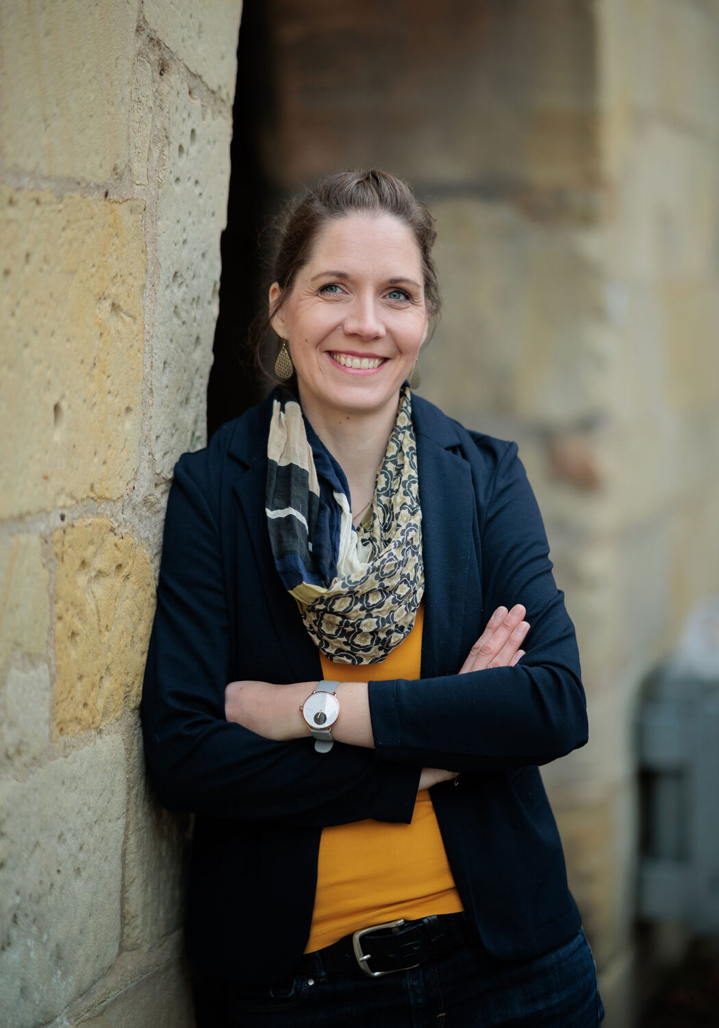 Portrait von Dorothea Deppermann vor Torbogen mit Steinen
